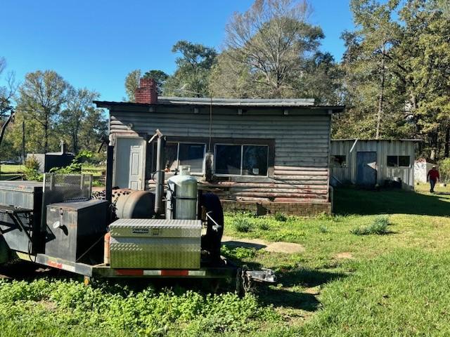 rear view of property with a yard