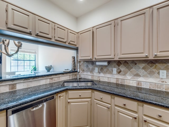 kitchen with sink, tasteful backsplash, stainless steel dishwasher, and dark stone counters