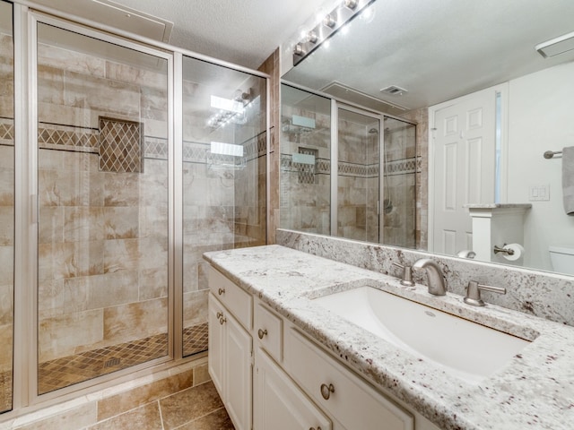 bathroom featuring vanity, a textured ceiling, tile patterned floors, and an enclosed shower