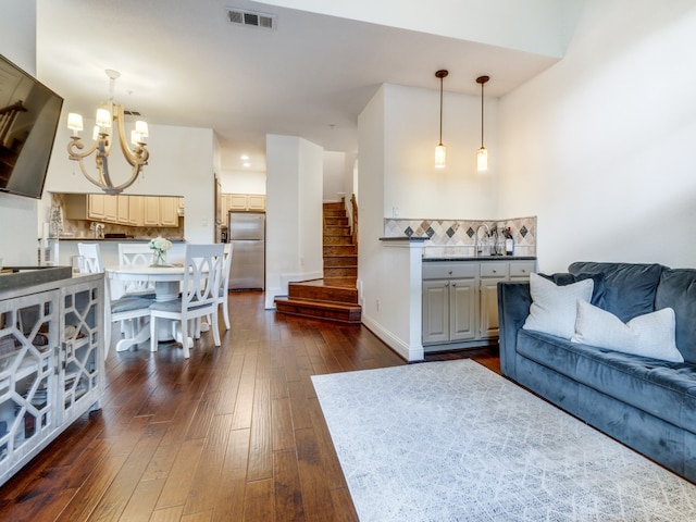 living room featuring a chandelier and dark wood-type flooring