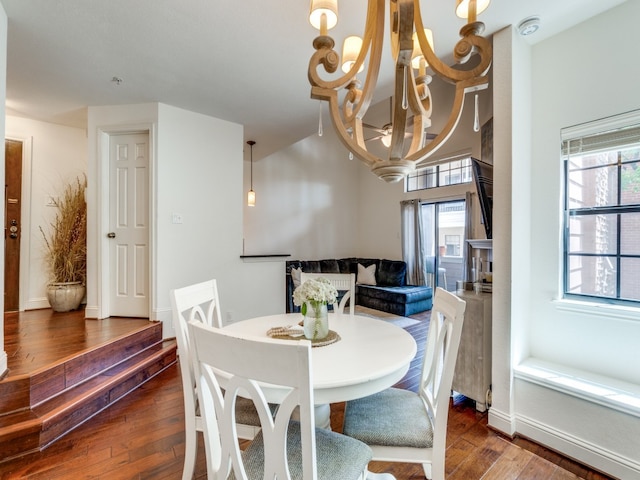 dining room with dark hardwood / wood-style flooring and an inviting chandelier