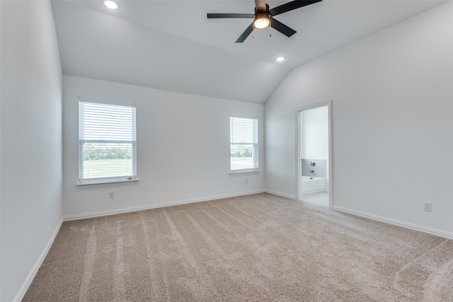 spare room featuring vaulted ceiling, ceiling fan, and light carpet