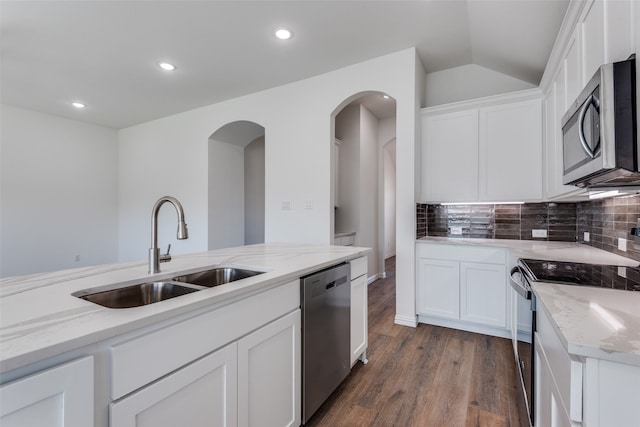 kitchen featuring dark hardwood / wood-style flooring, stainless steel appliances, white cabinetry, and light stone counters