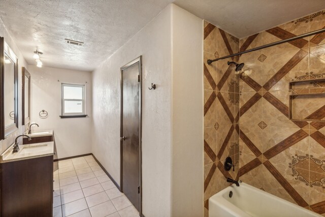 bathroom featuring vanity, a textured ceiling, tile patterned floors, and tiled shower / bath