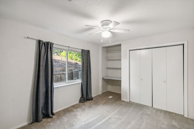 unfurnished bedroom with a closet, light colored carpet, and ceiling fan