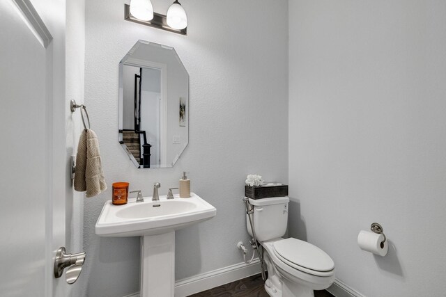 bathroom featuring sink, wood-type flooring, and toilet