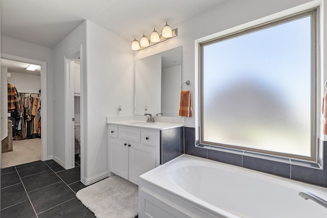 bathroom with tile patterned flooring, vanity, and a healthy amount of sunlight