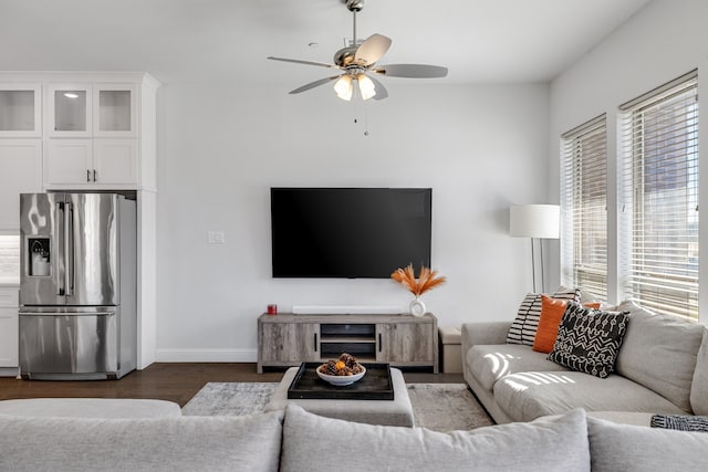 living room featuring a wealth of natural light, ceiling fan, and dark hardwood / wood-style floors