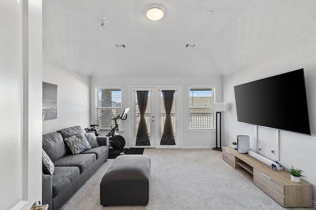 living room featuring light colored carpet, lofted ceiling, a wealth of natural light, and french doors