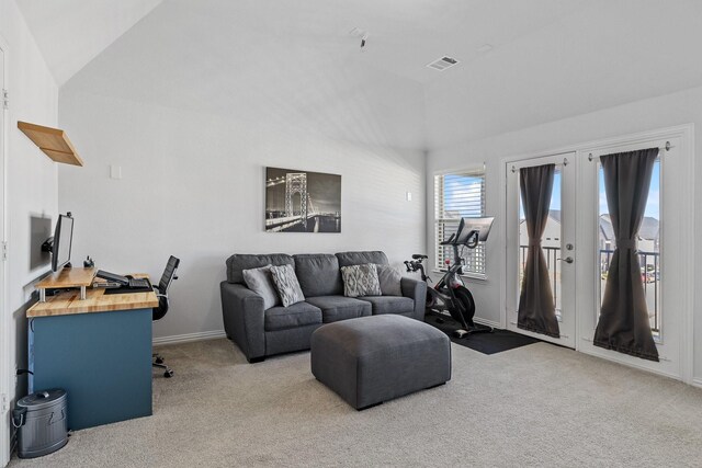 carpeted living room featuring lofted ceiling and french doors