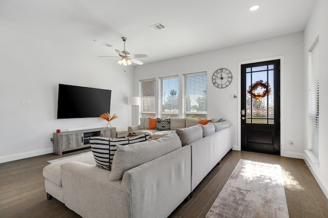 living room featuring ceiling fan and dark wood-type flooring