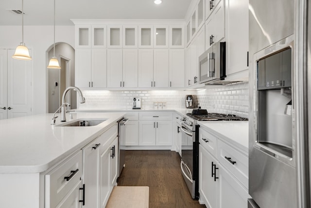 kitchen with stainless steel appliances, sink, dark hardwood / wood-style floors, white cabinetry, and hanging light fixtures