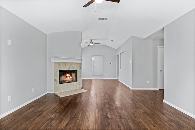 unfurnished living room with dark hardwood / wood-style flooring, ceiling fan, lofted ceiling, and a tiled fireplace