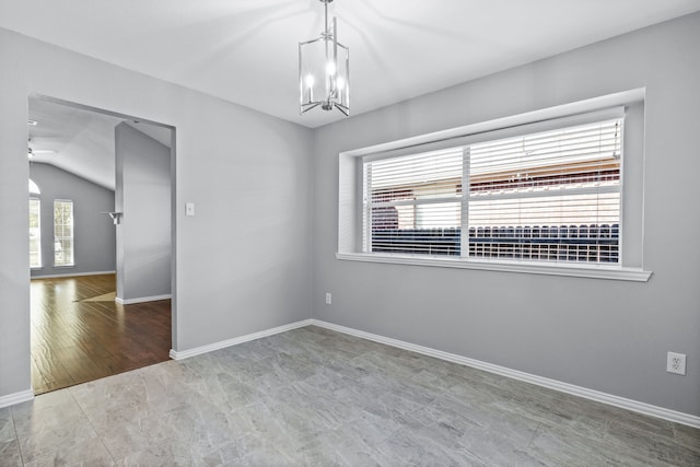 empty room featuring lofted ceiling and a notable chandelier