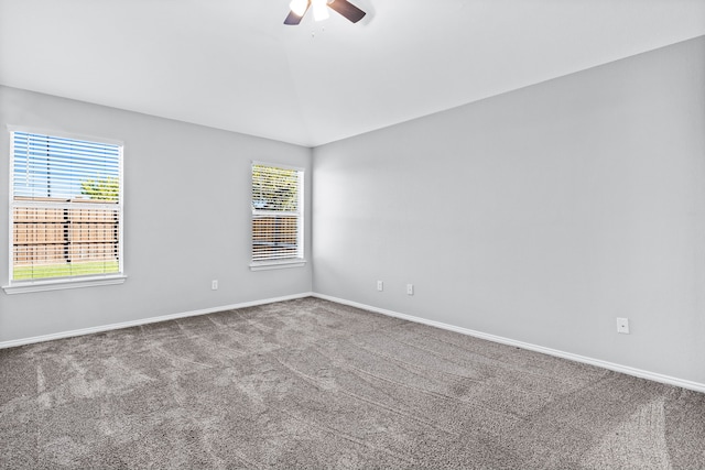 spare room featuring carpet, vaulted ceiling, and ceiling fan