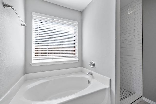 bathroom featuring a healthy amount of sunlight and plus walk in shower