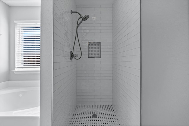 bathroom with a tile shower and a wealth of natural light