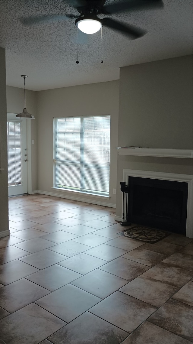 unfurnished living room with a textured ceiling and tile patterned floors