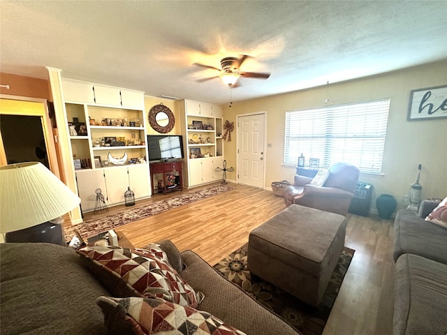 living room with ceiling fan, light hardwood / wood-style flooring, and a textured ceiling