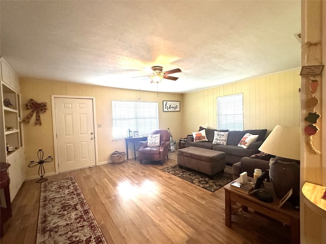 living room with a textured ceiling, hardwood / wood-style flooring, and ceiling fan