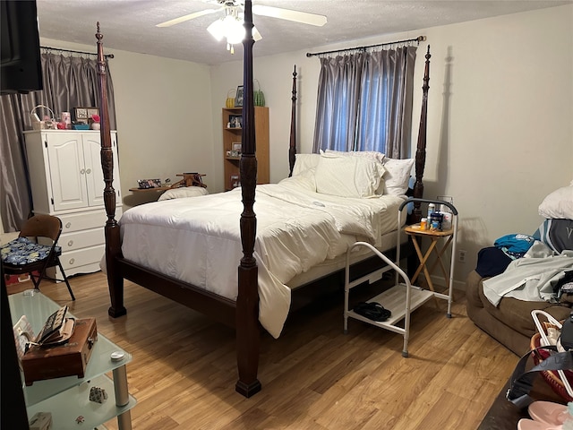 bedroom with ceiling fan, a textured ceiling, and light wood-type flooring