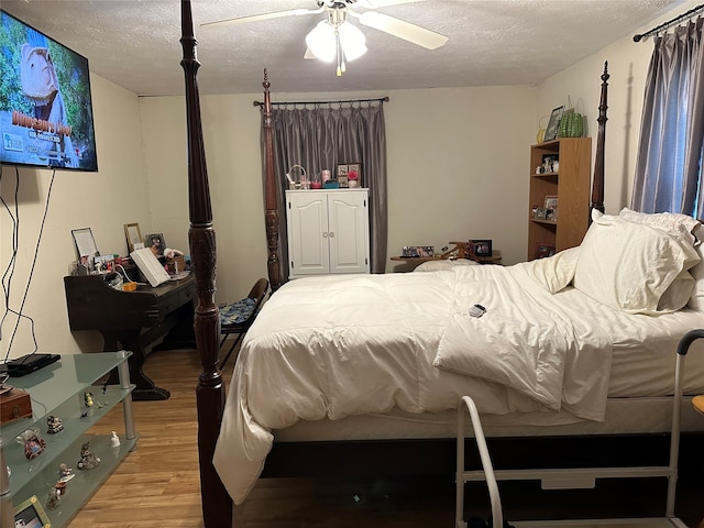 bedroom with a textured ceiling, hardwood / wood-style flooring, and ceiling fan