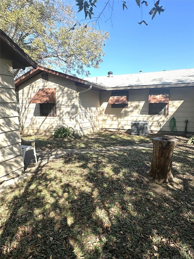 view of side of property featuring central AC and a yard