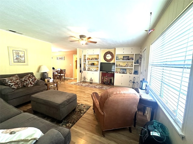 living room with hardwood / wood-style floors, a wealth of natural light, and ceiling fan