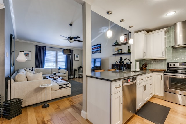 kitchen with white cabinetry, sink, light hardwood / wood-style flooring, kitchen peninsula, and appliances with stainless steel finishes