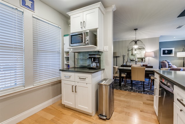 kitchen with white cabinetry, backsplash, light hardwood / wood-style floors, pendant lighting, and appliances with stainless steel finishes