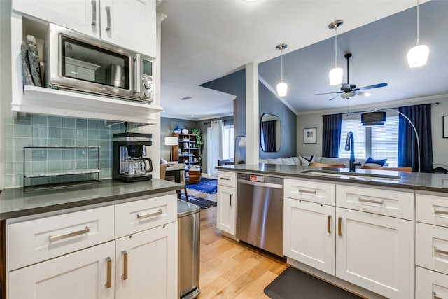 kitchen featuring light hardwood / wood-style flooring, white cabinets, appliances with stainless steel finishes, and crown molding