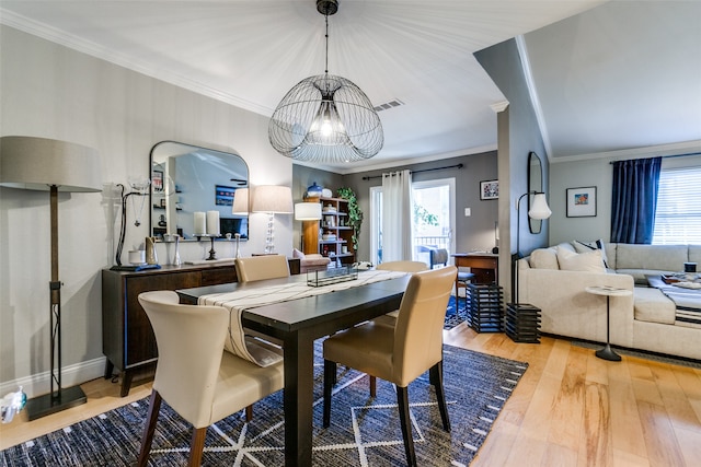 dining space featuring crown molding, light hardwood / wood-style flooring, a healthy amount of sunlight, and a notable chandelier