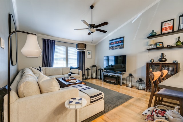 living room with hardwood / wood-style floors, ceiling fan, crown molding, and lofted ceiling