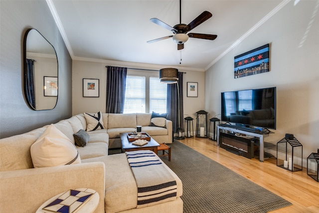 living room featuring hardwood / wood-style flooring, ceiling fan, and crown molding