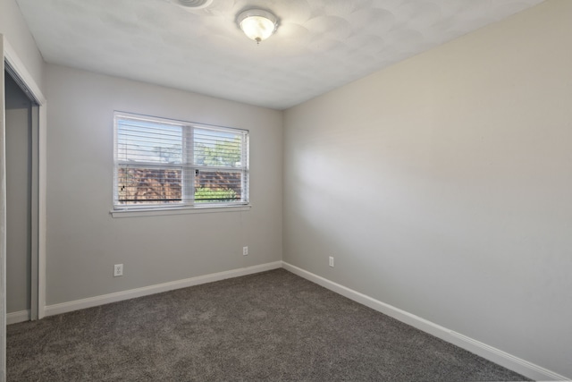 unfurnished bedroom with dark colored carpet