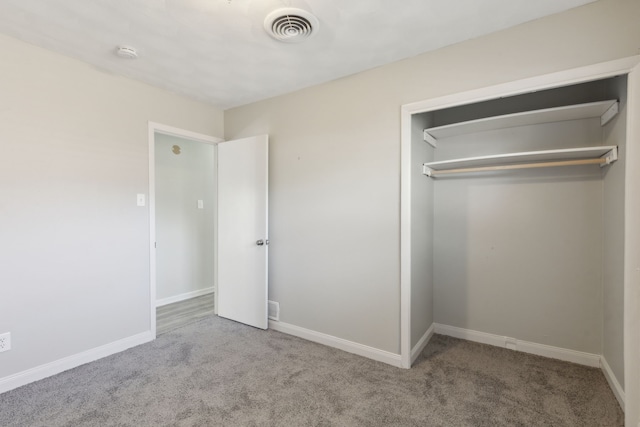 unfurnished bedroom featuring light colored carpet and a closet