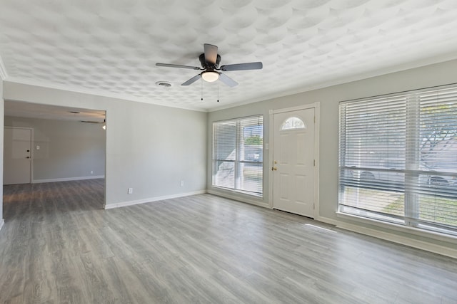 interior space with hardwood / wood-style floors, ceiling fan, a healthy amount of sunlight, and ornamental molding