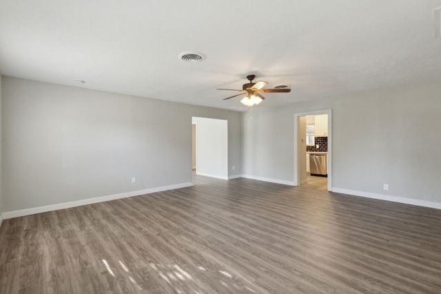 empty room with ceiling fan and dark hardwood / wood-style floors