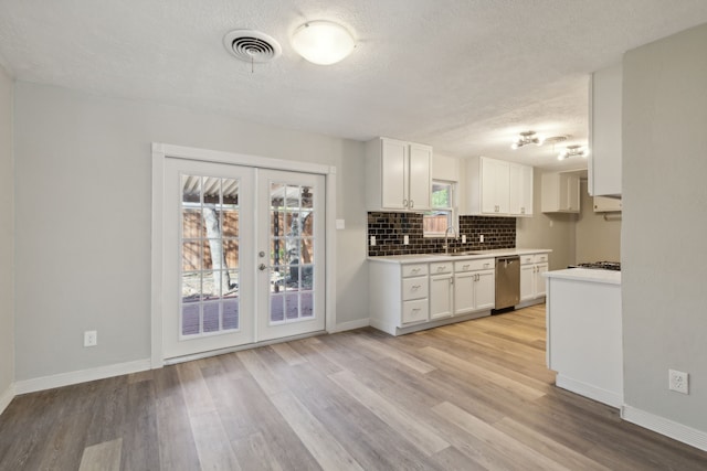 kitchen with dishwasher, french doors, white cabinets, sink, and light hardwood / wood-style floors