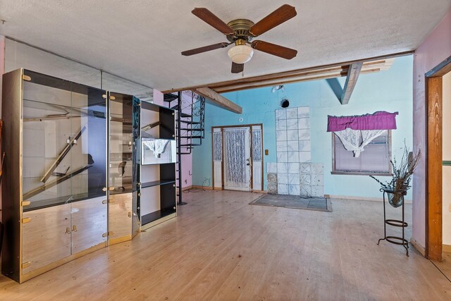 unfurnished living room with ceiling fan, hardwood / wood-style flooring, and a textured ceiling