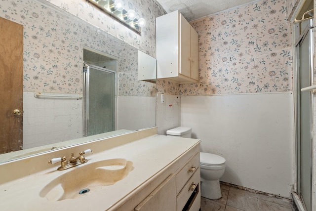 bathroom featuring a textured ceiling, vanity, tile patterned flooring, toilet, and a shower with shower door