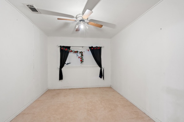 carpeted empty room with ceiling fan and crown molding