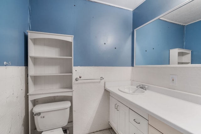 bathroom featuring vanity, toilet, and tile walls