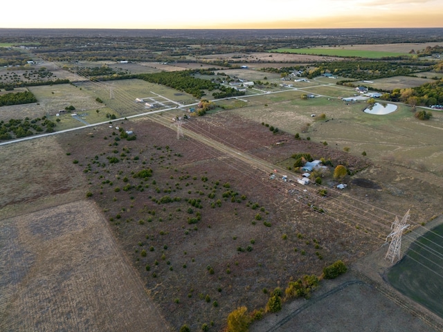 aerial view at dusk featuring a rural view