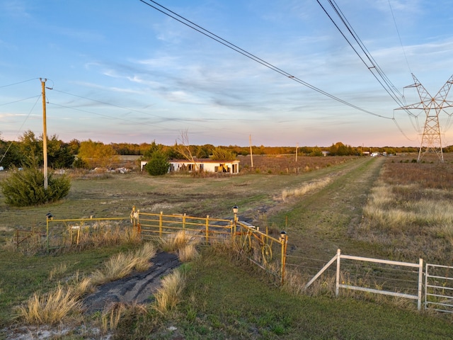 yard at dusk featuring a rural view