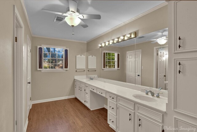 bathroom with wood-type flooring, vanity, ceiling fan, and crown molding