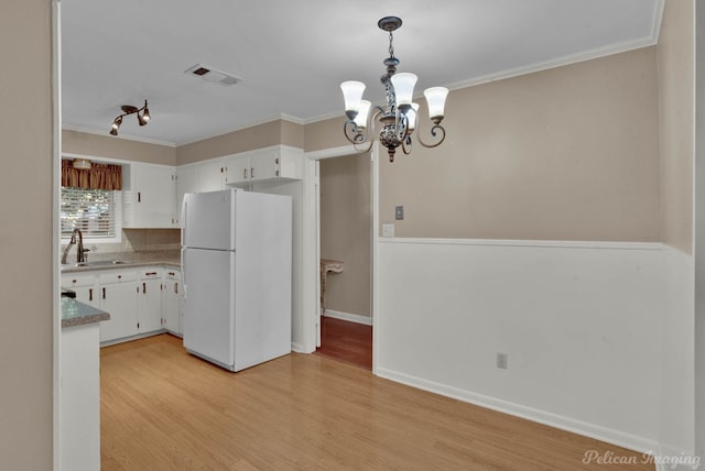 kitchen featuring white fridge, white cabinetry, a notable chandelier, and light hardwood / wood-style floors