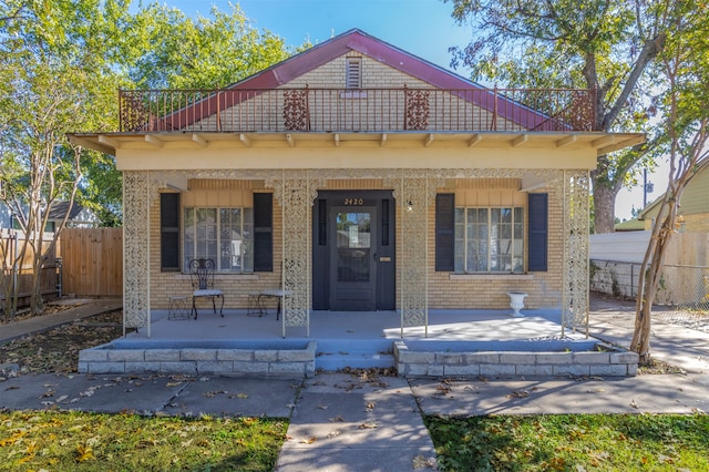 view of front of property featuring covered porch and a balcony