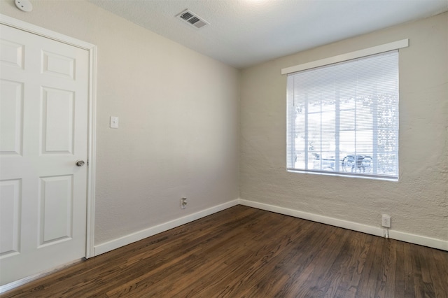 spare room with dark wood-type flooring