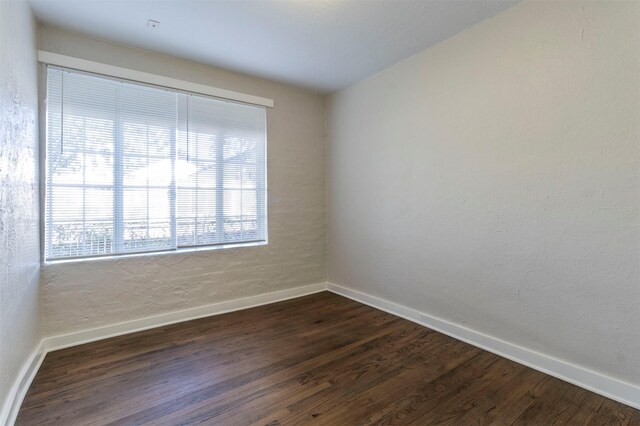 unfurnished room with dark hardwood / wood-style floors